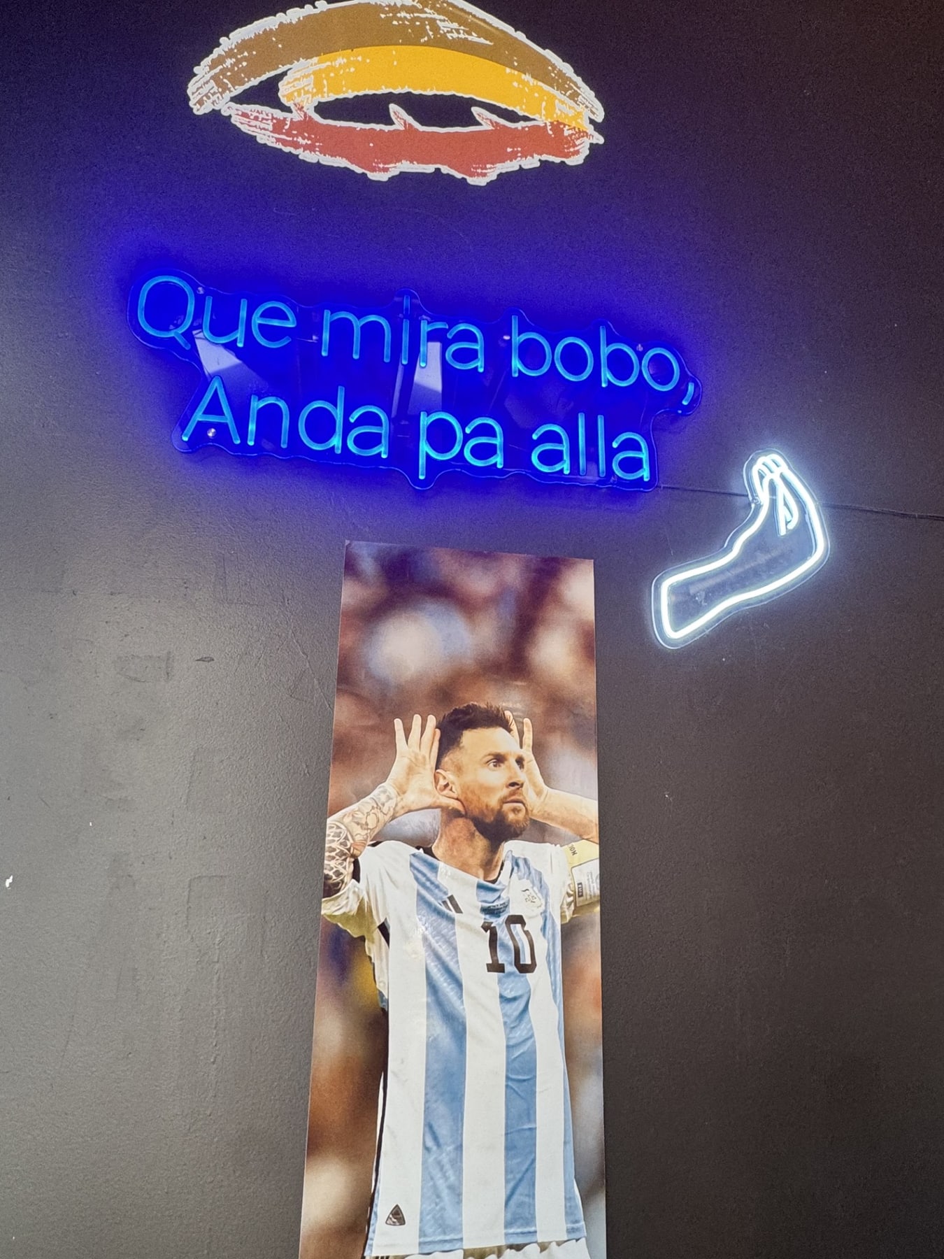Argentine fútbol art and a María Luisa neon sign at the restaurant