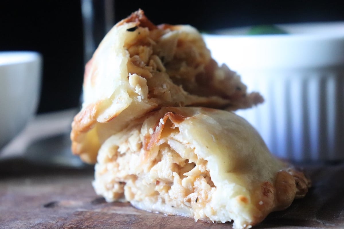 María Luisa chicken empanada with its filling visible