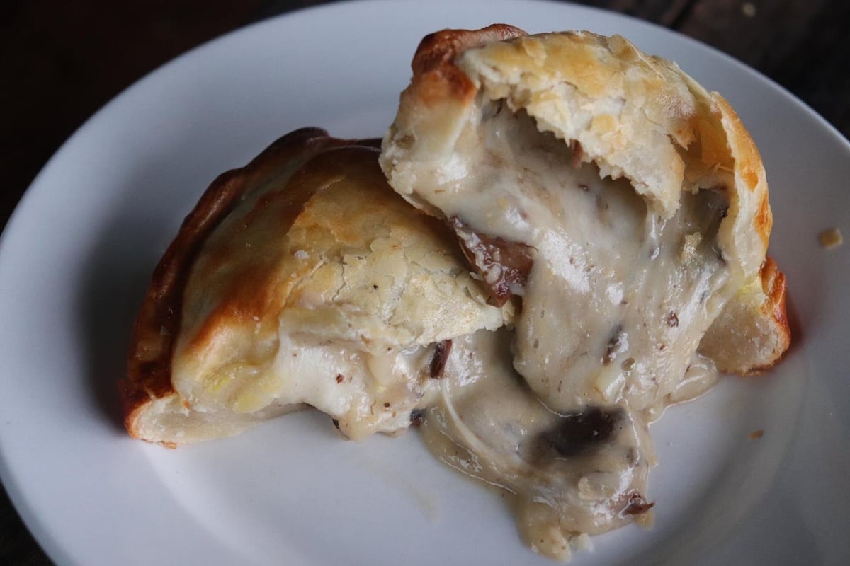 María Luisa mushrooms & cheese empanada with its filling visible